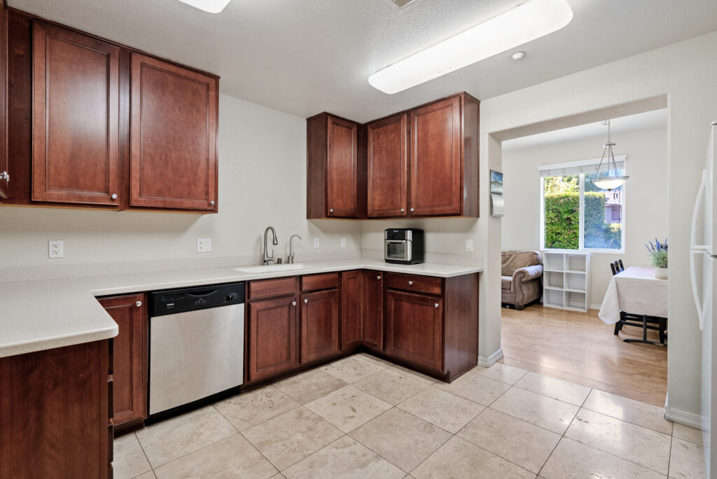 Spacious kitchen with dual sinks, dishwasher, and cherry wood cabinets