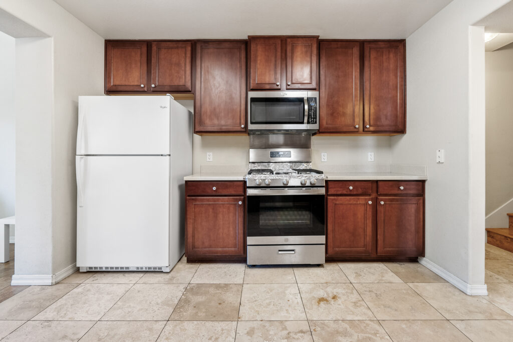 Modern kitchen with stainless steel gas range, microwave, and full-size refrigerator