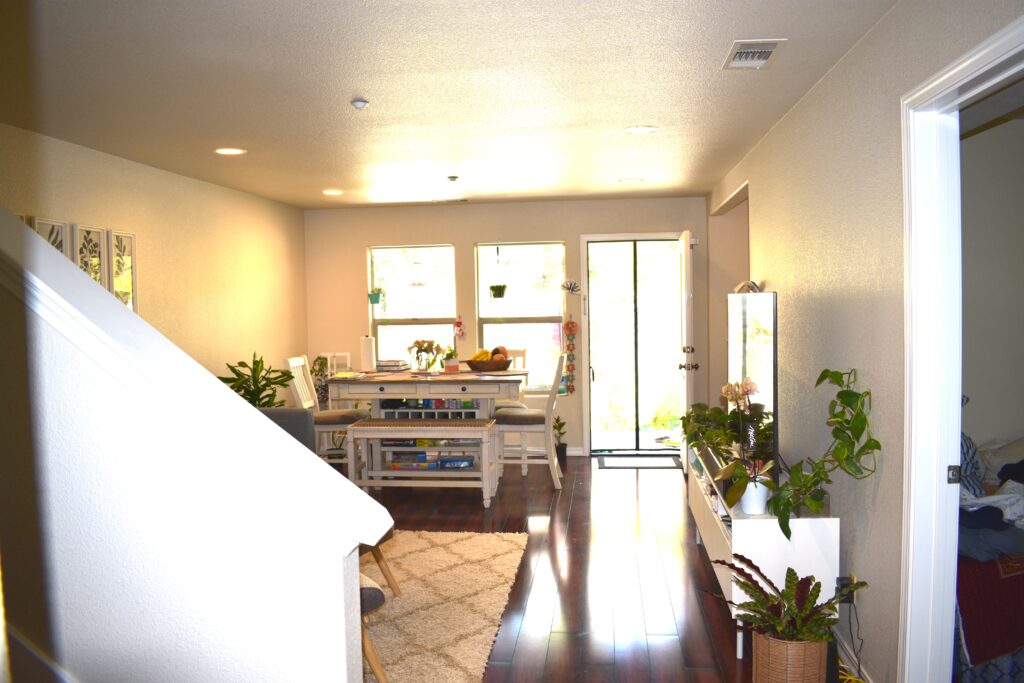 Open-concept living and dining area with natural light, hardwood floors, and direct access to the backyard patio.