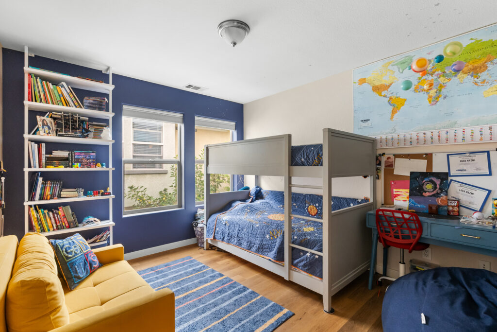 Kids' bedroom with bunk beds, bookshelf, and space-themed decor at 545 Paseo Bella Montana.